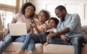 happy family with devices on a couch