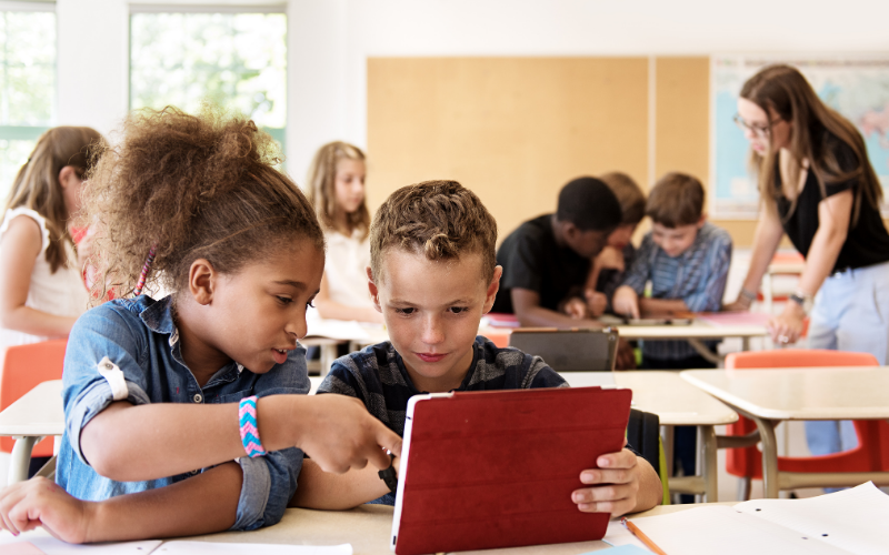 kids use tablets together in a classroom