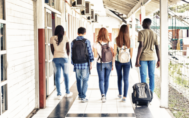 five young people walking at a school