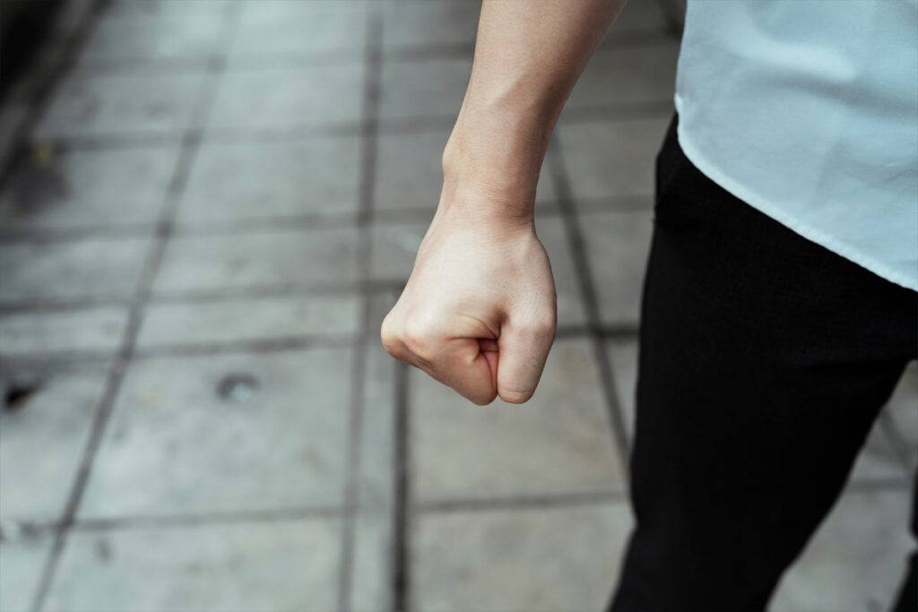 young person's clenched fist held at side
