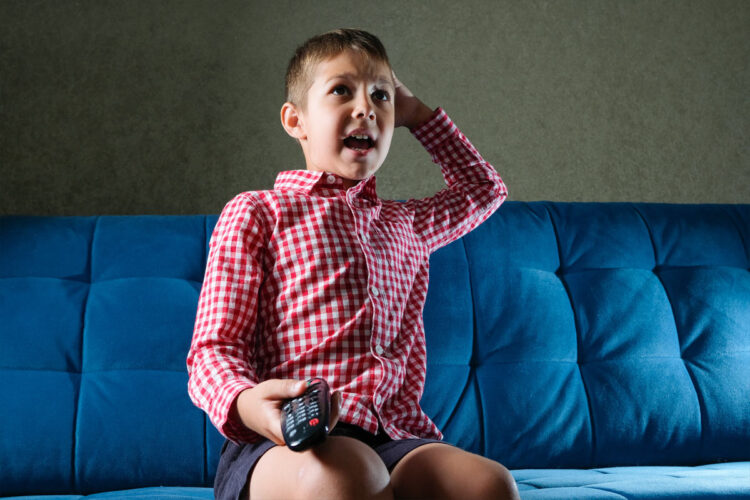excited child on couch with tv remote
