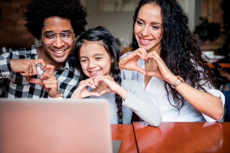 family of three making hearts with hands toward webcam