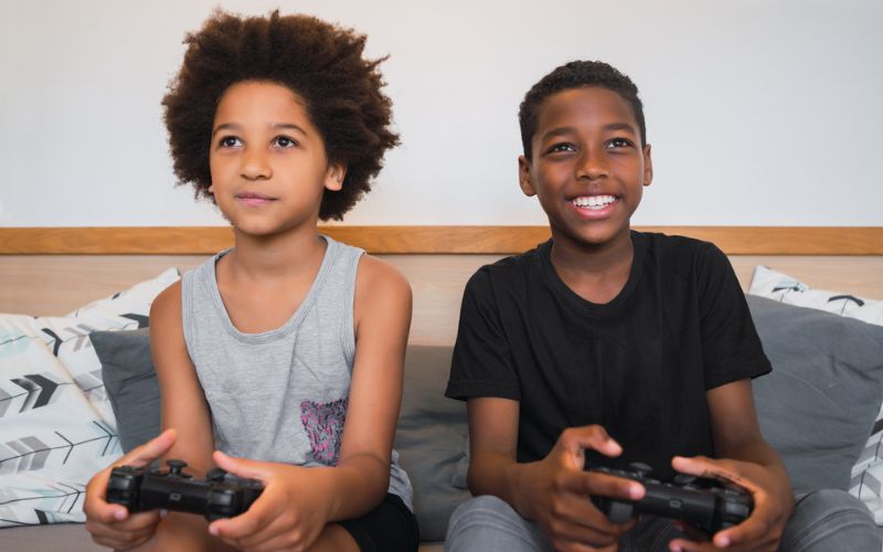 Two kids on a couch playing video games