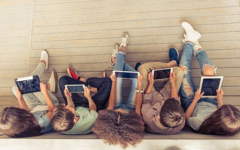 Top view of young people sitting with tablets