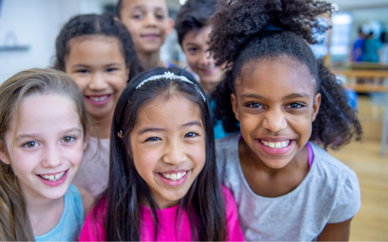 ix School-aged kids crowding in to smile for the camera