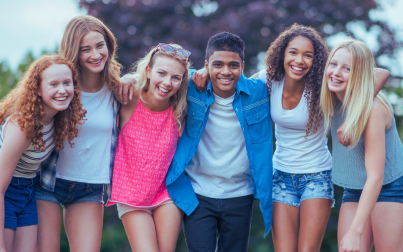Six young people with arms over each other's shoulders