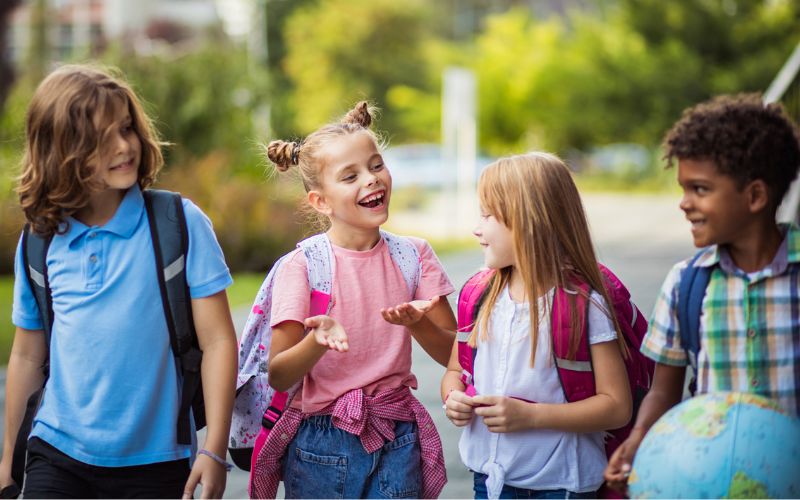 Four kids with school backpacks