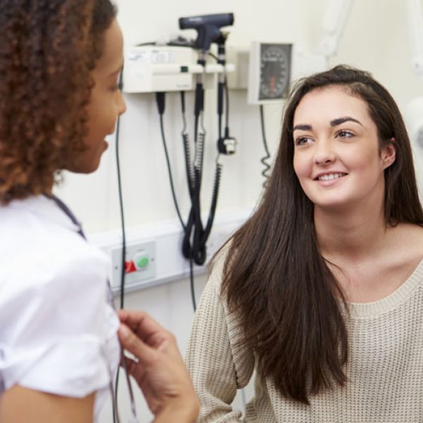 a clinician meeting with a teen patient