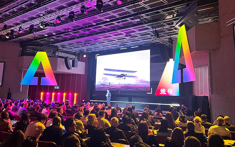 A large crowd watches a presentation at the summit