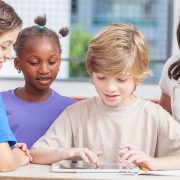 children around a tablet at school