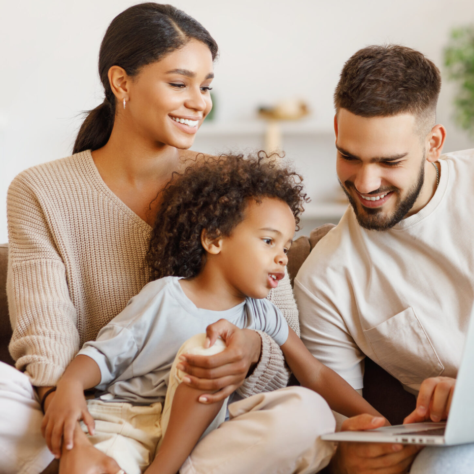 young family of three with a laptop